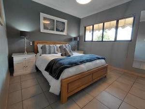a bedroom with a large bed and two windows at Executive Flat with Stunning Views in Westville