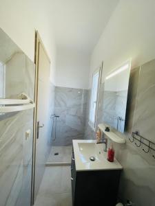 a white bathroom with a sink and a shower at Stella Collection in Kranidi +6 photos