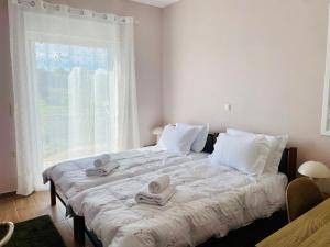 a bedroom with a large bed with towels on it at Stella Collection in Kranidi