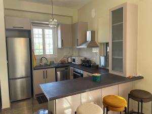 a kitchen with a counter and some stools in it at Stella Collection in Kranidi