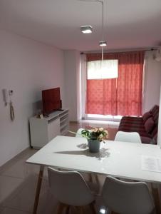 a living room with a white table and chairs at Edificio Leonardo Premium Centro Las Heras in Villa Carlos Paz