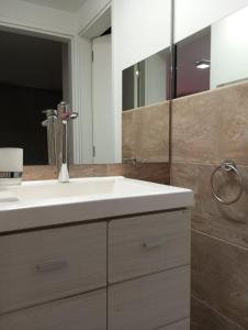 a bathroom with a white sink and a mirror at Edificio Leonardo Premium Centro Las Heras in Villa Carlos Paz +5 photos