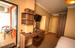 a hotel room with a desk and a bedroom at Hotel Montana in Sarpi