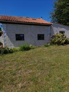 a small white house with a grass yard at Maison Vacances in Saint-Savinien