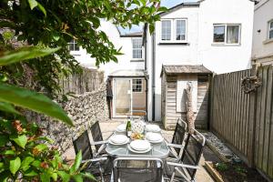 a table and chairs in the backyard of a house at Stade Cottage in Hythe