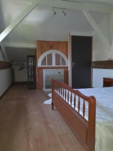 a bedroom with a bed and a wooden floor at Maison Vacances in Saint-Savinien
