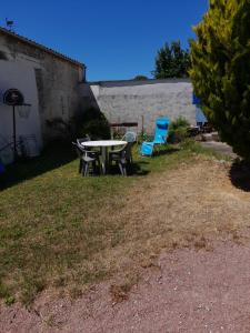 a picnic table and chairs in a yard at Maison Vacances in Saint-Savinien +5 photos