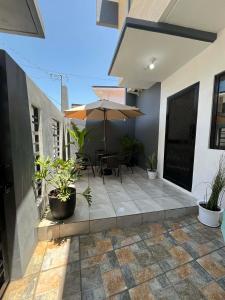 a patio with an umbrella and chairs and plants at Modern Home and Stylish Design in Ibaba