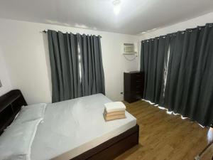 a bedroom with a bed with green curtains at Modern Home and Stylish Design in Ibaba