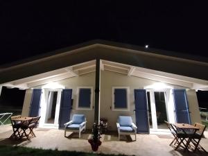 eine Terrasse mit Stühlen und Tischen bei Nacht in der Unterkunft B&bo in Pesaro