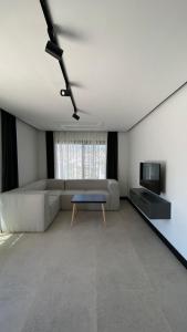 a living room with a couch and a tv at Bodrum Has Apart Otel in Bodrum City