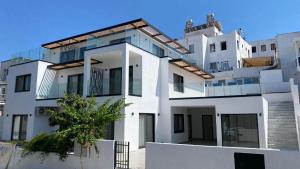 a white building with a tree in front of it at Bodrum Has Apart Otel in Bodrum City