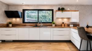 a kitchen with white cabinets and a sink at Villa Confidentielle Opale in Merlimont