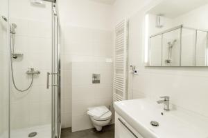a white bathroom with a shower and a toilet at Lakeside Village - Větrník in Frymburk +28 photos