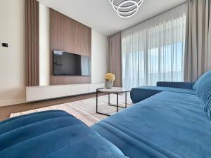 a living room with a blue bed and a tv at BW Perla - Premium Apartments in Belgrade