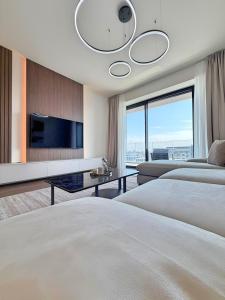 a hotel room with two beds and a flat screen tv at BW Perla - Premium Apartments in Belgrade +55 photos