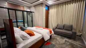 a bedroom with a bed and a chair at The Yoyo's Stay in Arusha