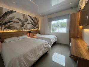 a hotel room with two beds and a window at APARTAMENTOS TURISTICOS ALTAMAR in San Andrés