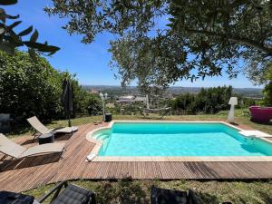 a swimming pool on a wooden deck with chairs around it at Maison avec piscine et vue panoramique in Albi