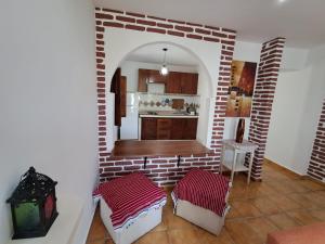 a kitchen with a brick wall and two stools at Dar YLA in Tétouan