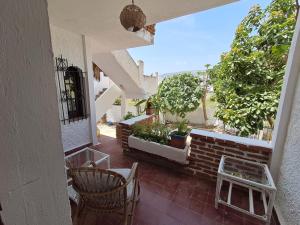 a patio with chairs and trees and a brick wall at Dar YLA in Tétouan