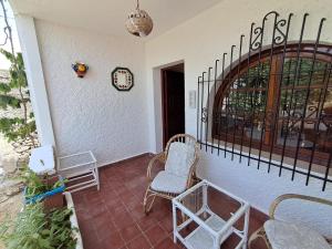 a porch with chairs and a clock on the wall at Dar YLA in Tétouan +7 photos