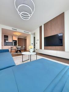 a living room with a blue bed and a tv at BW Perla - Premium Apartments in Belgrade
