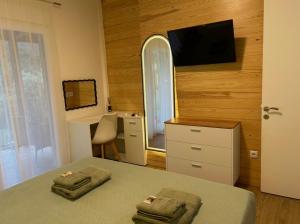 a bedroom with a bed and a tv on a wall at Abigails Pool House in Kallirákhi