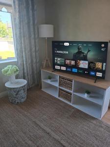 a living room with a flat screen tv on a tv stand at Judys View in Cashel