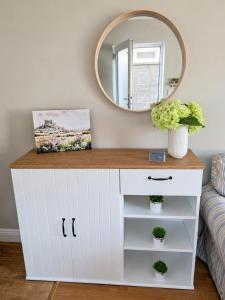 a white dresser in a living room with a mirror at Judys View in Cashel