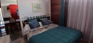 a bedroom with a green bed with blue pillows at Le Papyrus in Cilaos