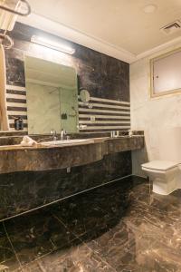 a bathroom with a sink and a mirror at Nile Suites Plaza Hotel Apartments in Cairo +51 photos