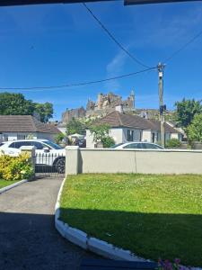 a house with a fence and a yard with cars at Judys View in Cashel