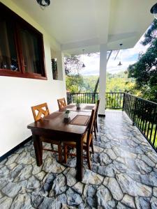 a dining room with a table and chairs on a balcony at Ameliora Ella in Ella