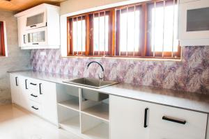 a kitchen with white cabinets and a sink at Villa Hima Arana in Galle