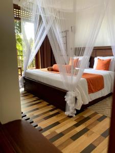 a bedroom with a bed with mosquito netting at Ameliora Ella in Ella