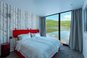 a bedroom with a large bed and a large window at Cormorant Rock Chalets in Ingonish Beach