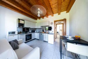 a kitchen with white cabinets and a white couch at B&B We CaRe Appartamento in Lendinara