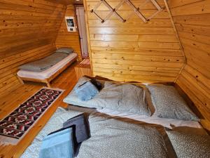 a room with two beds in a wooden cabin at Hiška Polhec in Bovec