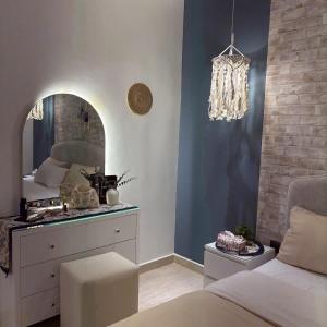 a bedroom with a vanity and a mirror and a bed at Greek Home4 in Al Khobar