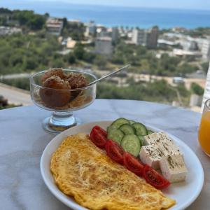 a plate of food with omelet and vegetables on a table at Vila Alexandros in Qeparo