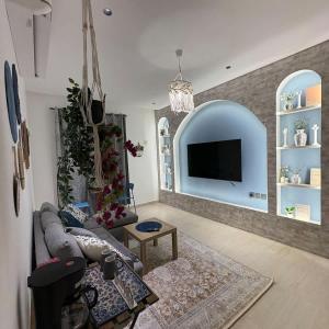 a living room with a couch and a flat screen tv at Greek Home4 in Al Khobar +30 photos