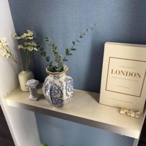 a blue and white vase sitting on a shelf with a plant at Greek Home4 in Al Khobar