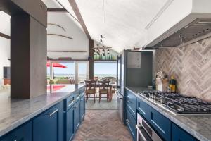 a kitchen with blue cabinets and a view of the ocean at Beachfront on Commercial St Dog Friendly in Provincetown