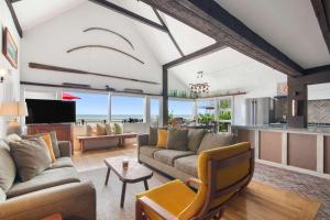 a living room with couches and a tv and a kitchen at Beachfront on Commercial St Dog Friendly in Provincetown