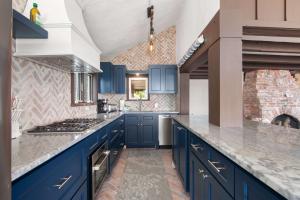 a kitchen with blue cabinets and granite counter tops at Beachfront on Commercial St Dog Friendly in Provincetown