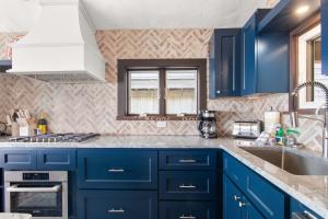 a kitchen with blue cabinets and a sink at Beachfront on Commercial St Dog Friendly in Provincetown +28 photos