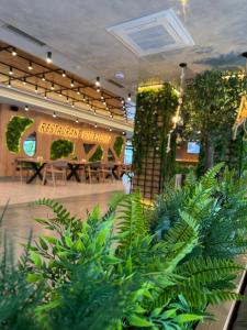 a lobby with plants and a table in the background at Family Hotel Gotse Delchev in Gotse Delchev