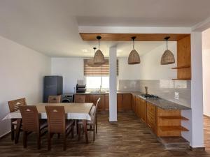 a kitchen and dining room with a table and chairs at Diar Jabal Villa S2 in Banī ‘Aţāʼ