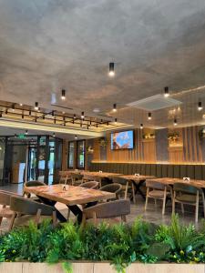 a restaurant with tables and chairs and a tv at Family Hotel Gotse Delchev in Gotse Delchev